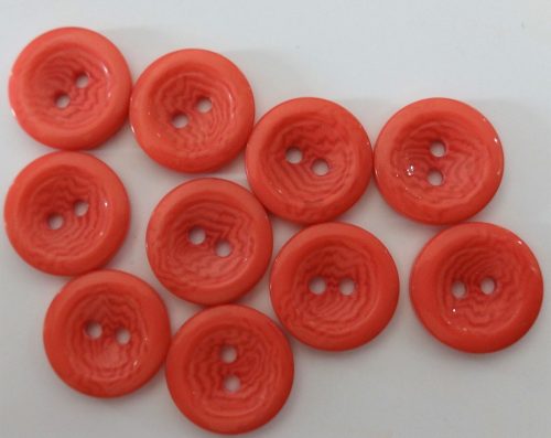 Eper színű, két lyukú műanyag gomb, átmérő 18 mm.